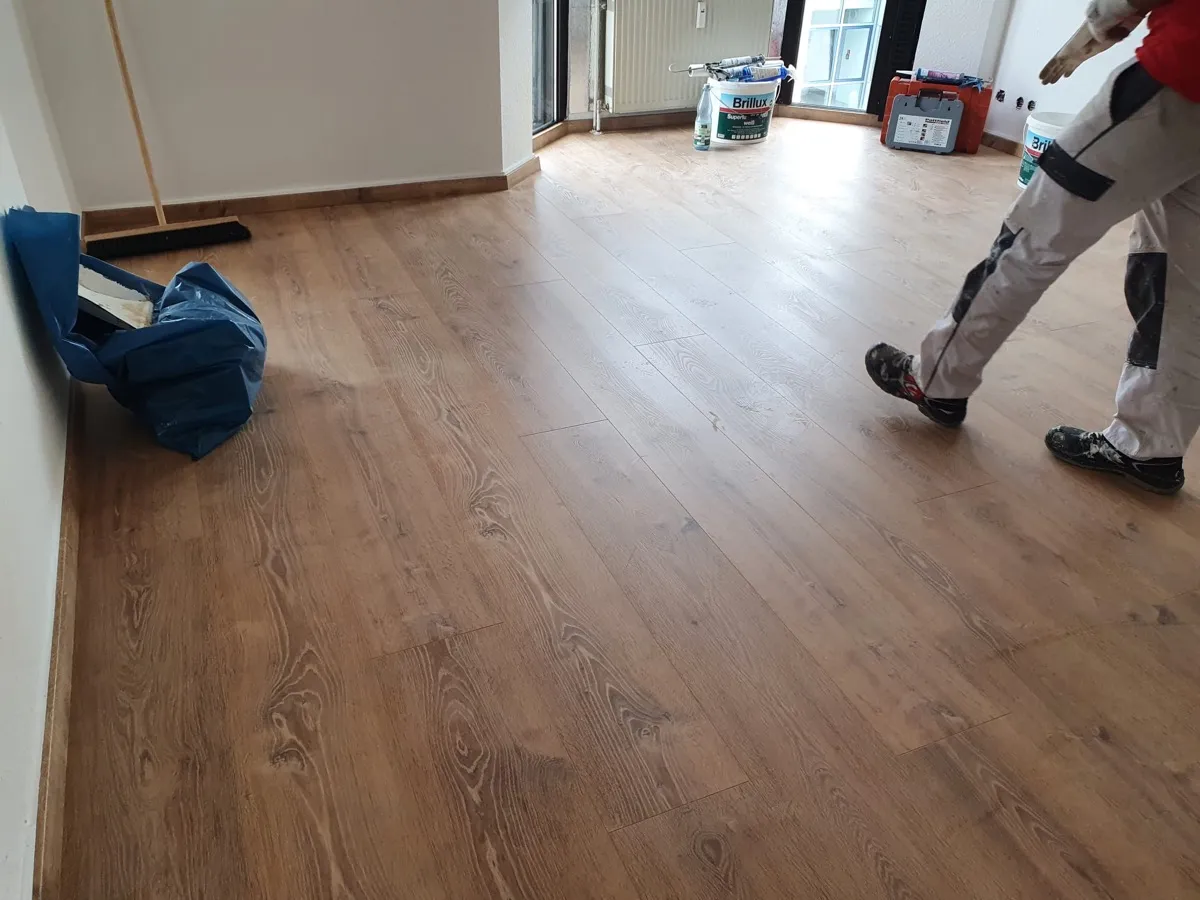 Maler mit Brillux Farbe auf sauberem Laminatboden