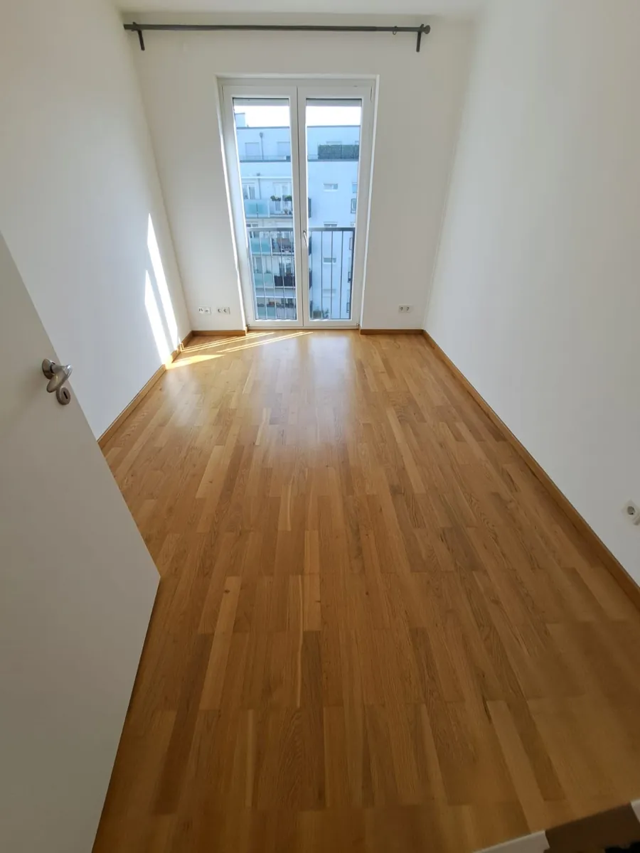 Wei&szlig; gestrichenes Schlafzimmer mit Balkont&uuml;r und Parkett