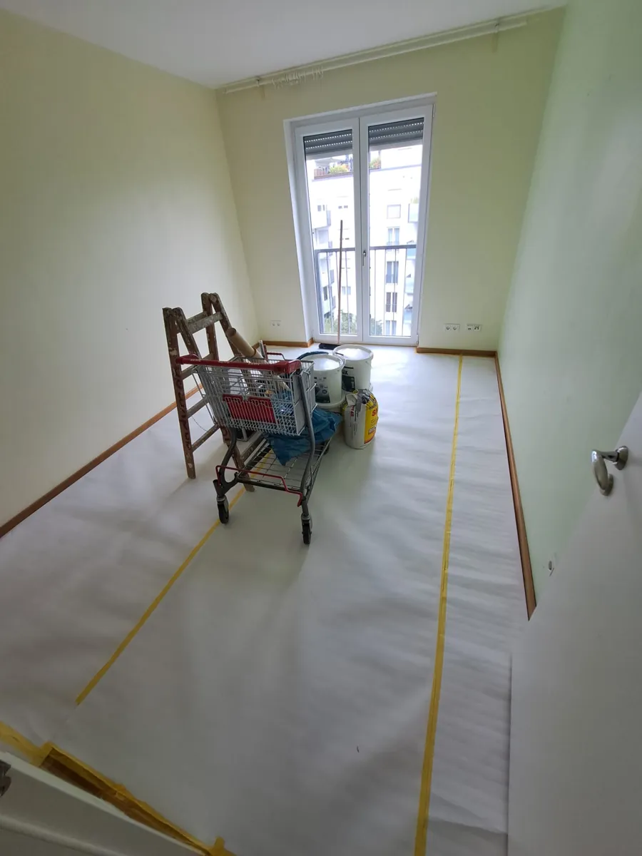 Gr&uuml;n gestrichenes Zimmer vor dem Neuanstrich mit Material auf dem Abdeckvlies