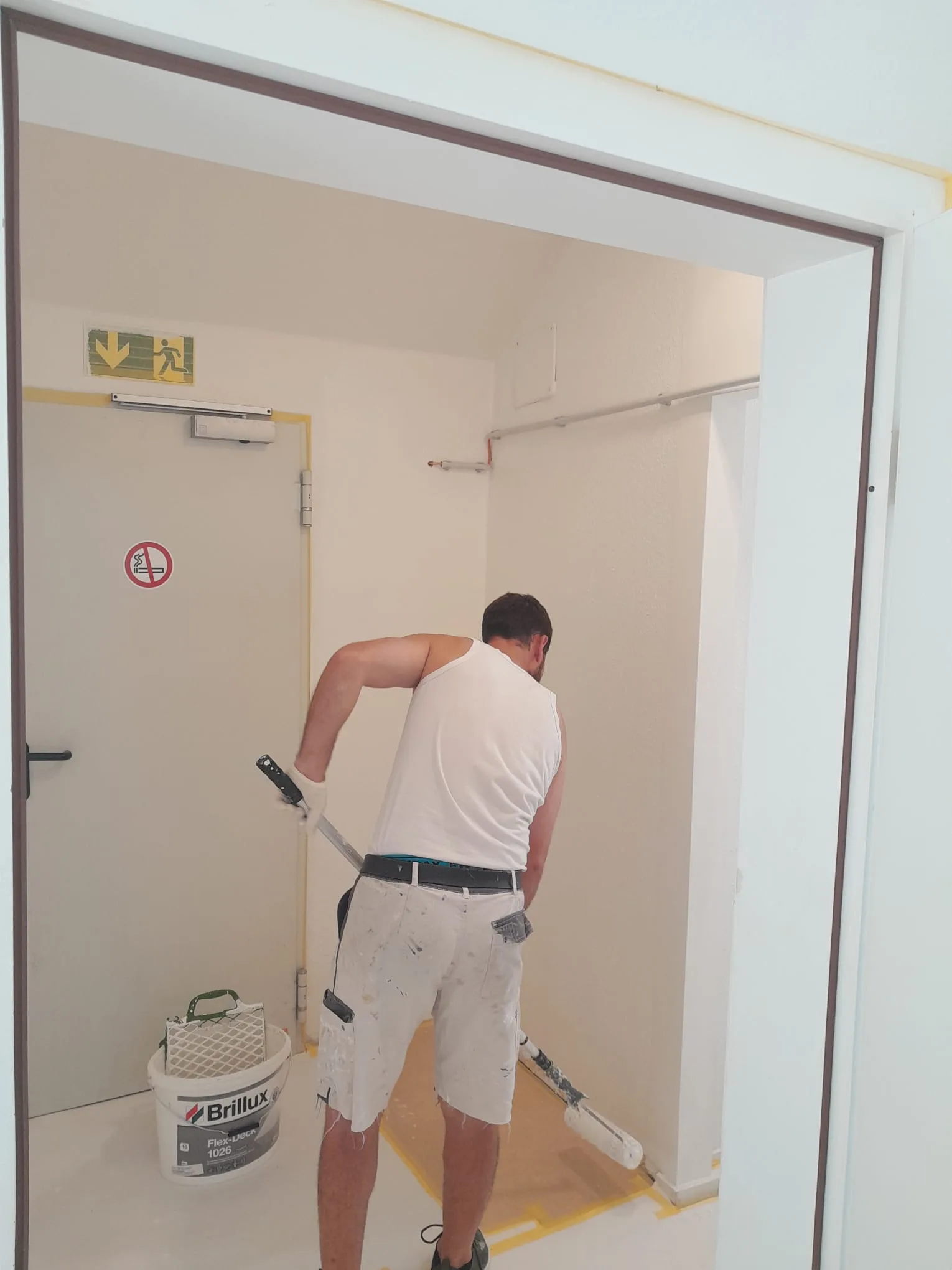 Andymen-Maler streicht Wand mit Farbroller in Dachgeschosswohnung Hochheim, Brillux Flex-Deck