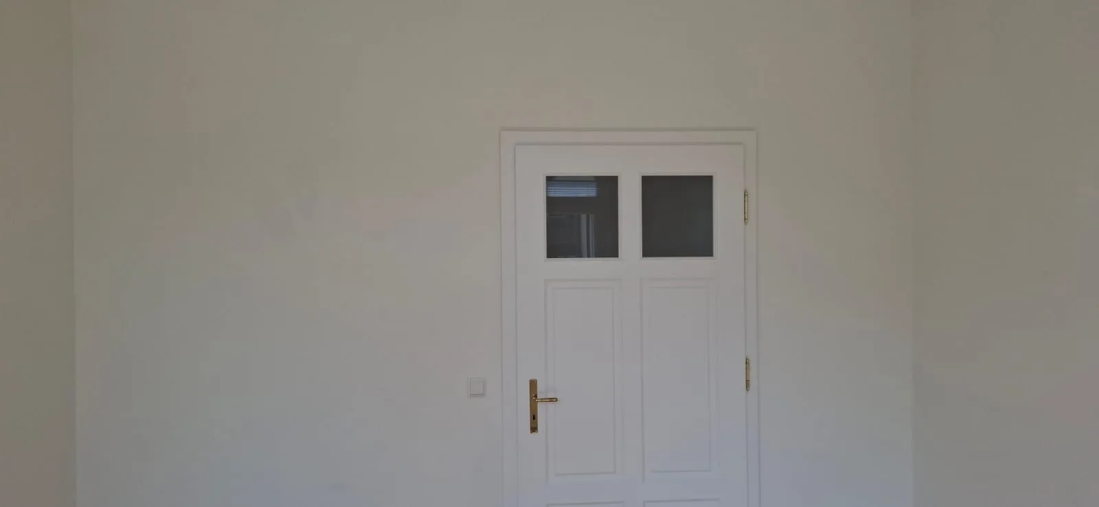 Fertig gestrichener Flur in Marburg mit Blick zur Balkontuer, bezugsfertig