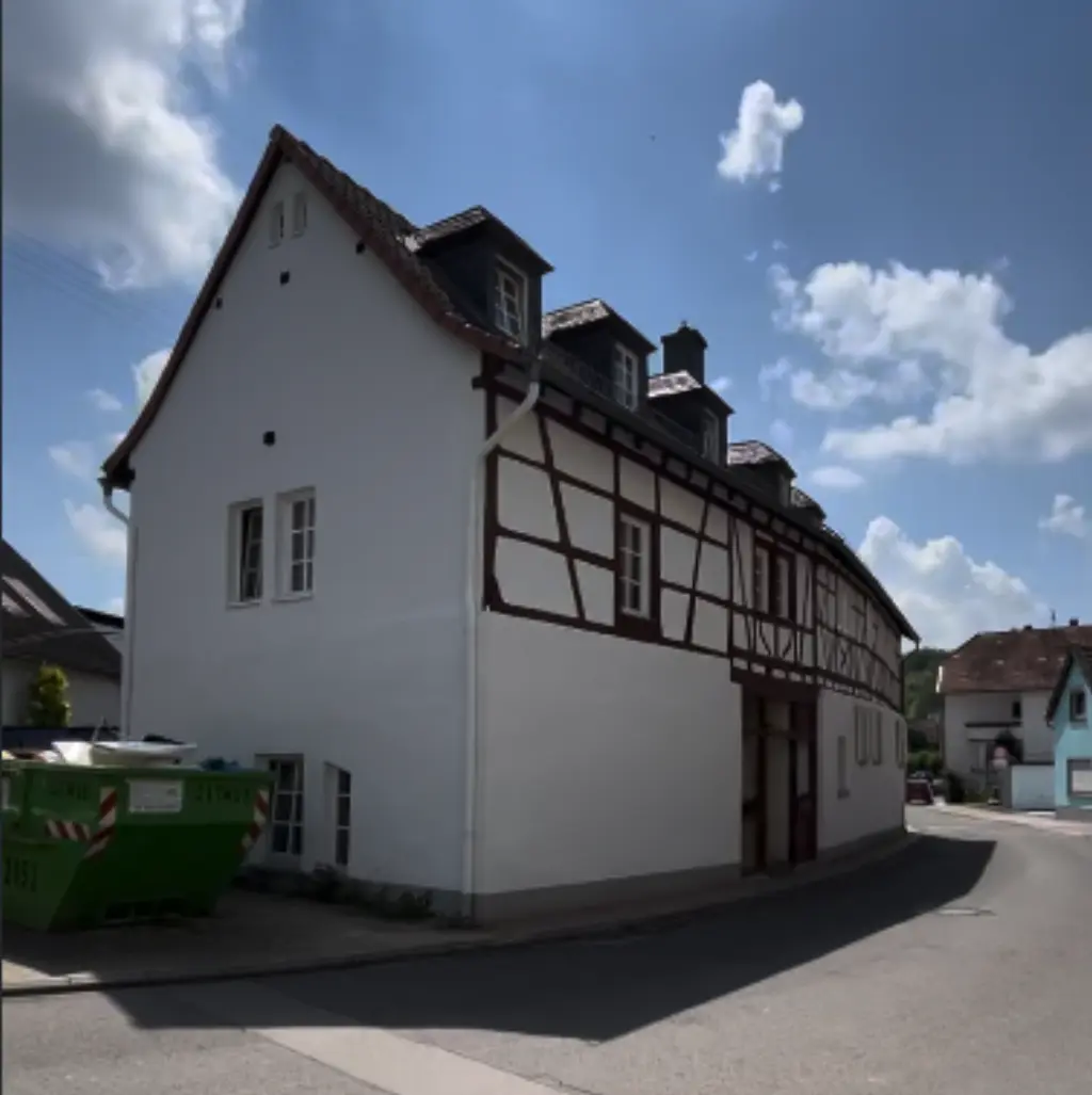 Fachwerkhaus komplett saniert nachher — weisse Fassade, sauberes Fachwerk, neue Fenster