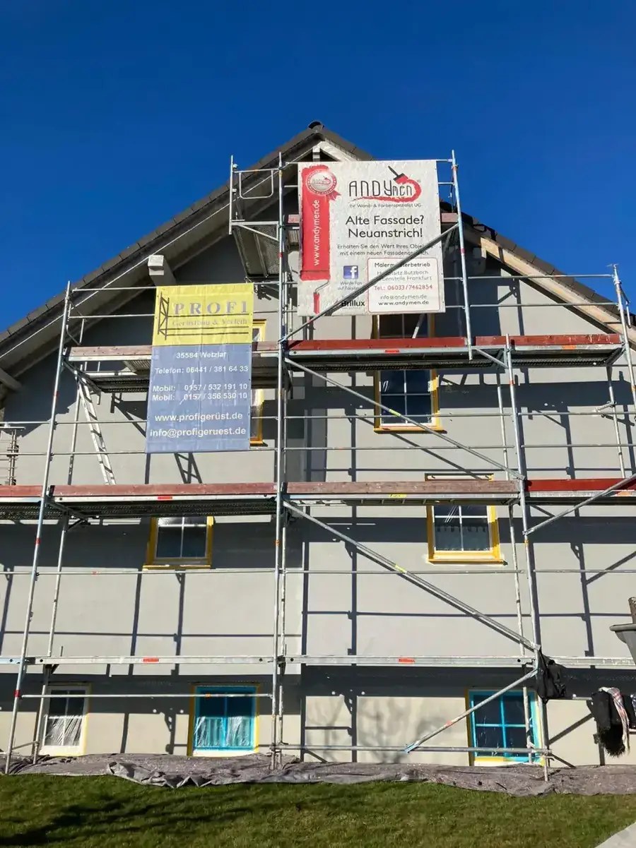 2-Familienhaus Gambach-Muenzenberg nachher — moderne graue Fassade mit Andymen-Banner