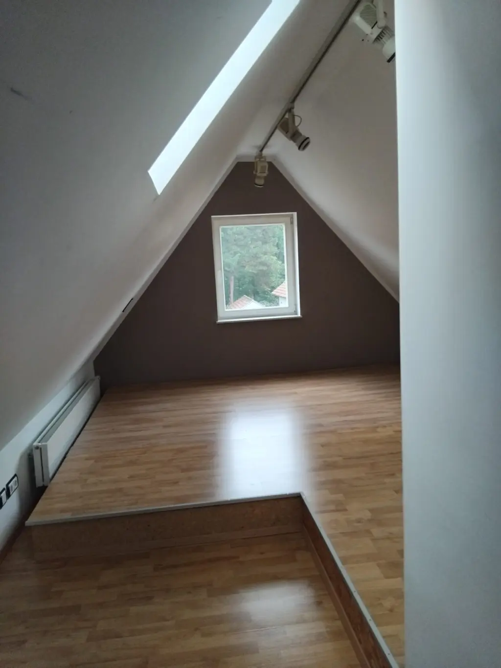 Dachgeschoss vorher — leerer Raum mit brauner Akzentwand