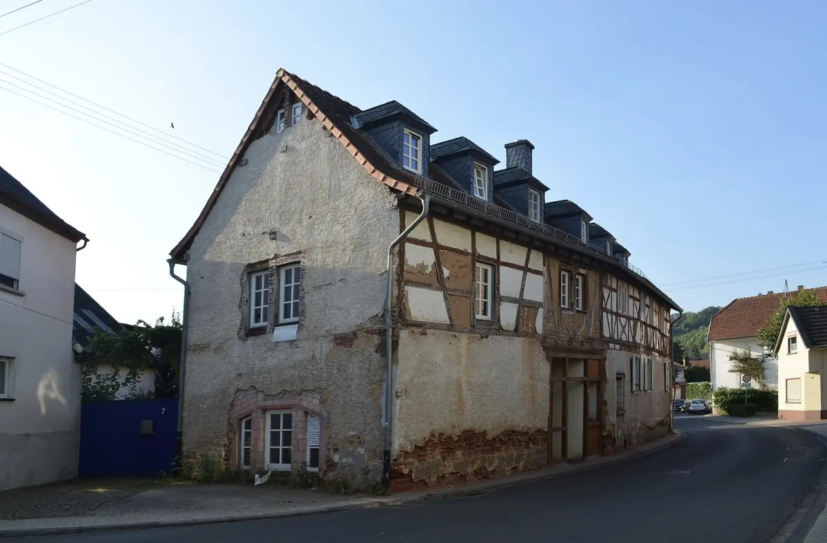 Fachwerkhaus nach 20 Jahren Leerstand vorher — verfallene Fassade, abbroeckelnder Putz, offenes Fachwerk