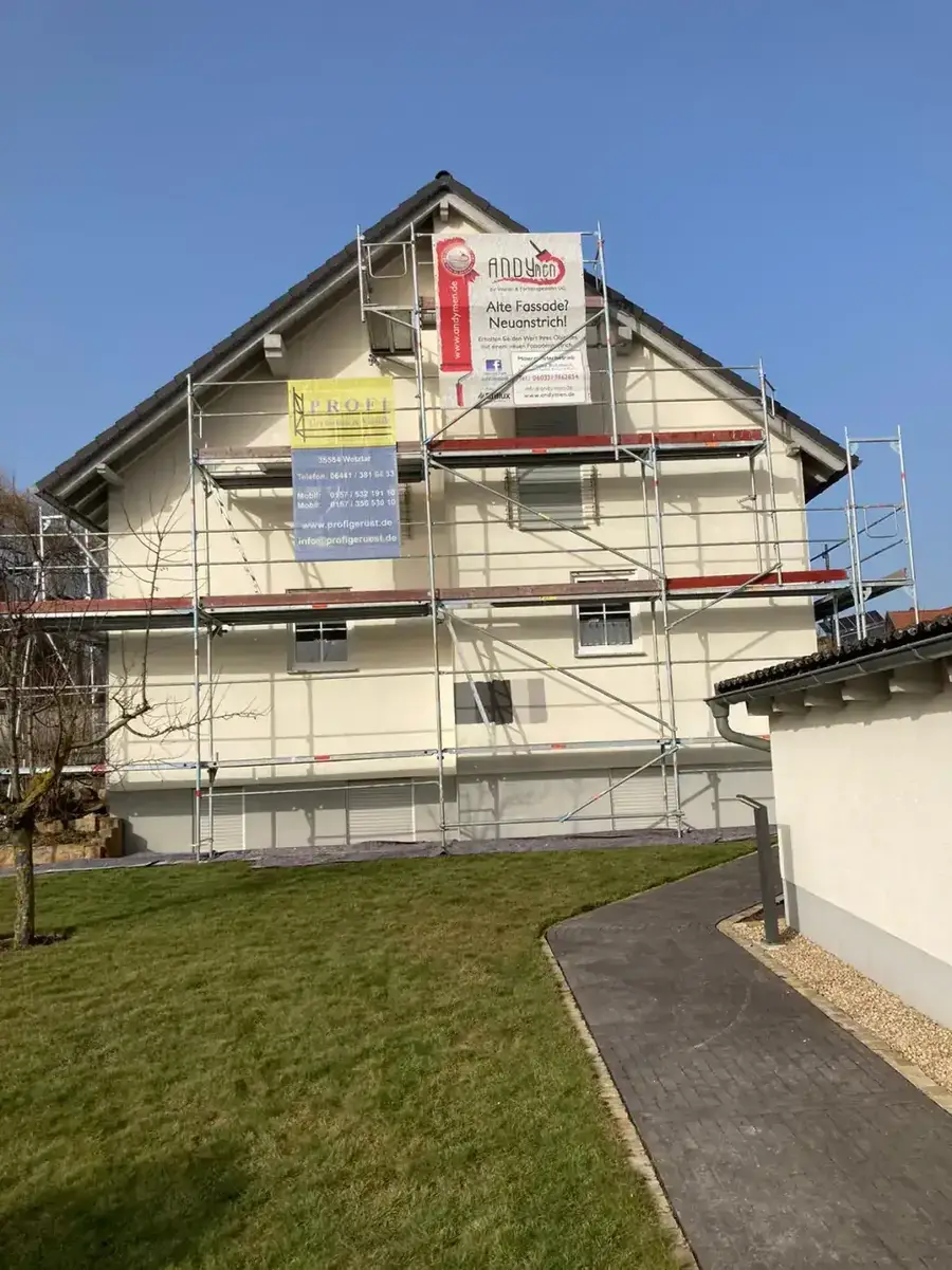 2-Familienhaus Gambach-Muenzenberg vorher — gelbliche Fassade mit Geruest und Andymen-Banner