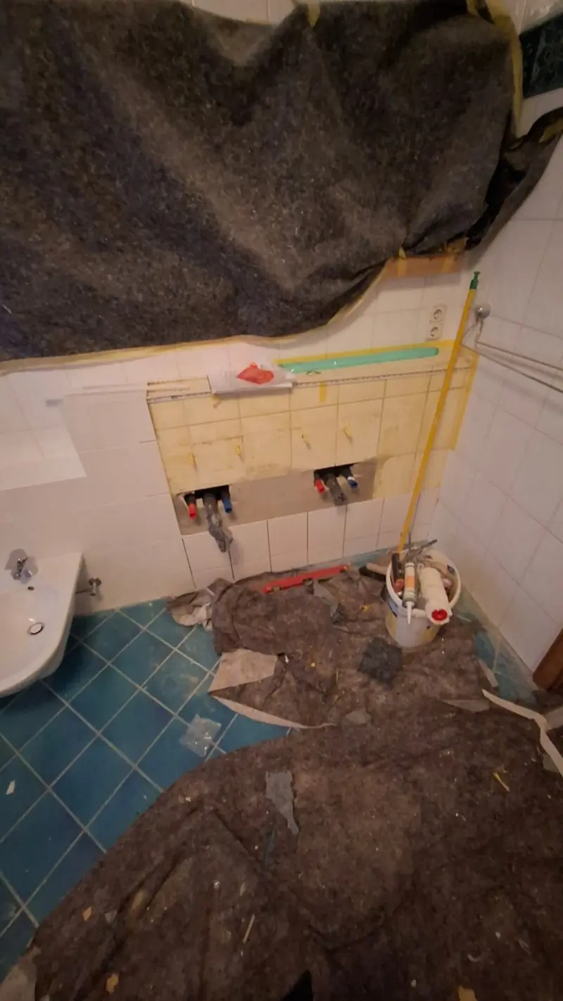 Bad vor der Renovierung — altes Badezimmer mit abgerissenen Fliesen, Andymen Maler mit Stern