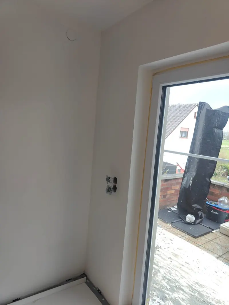 Wand vor dem Anstrich — frisch gespachtelte Wände mit Steckdosen-Aussparungen, Andymen Maler mit Stern