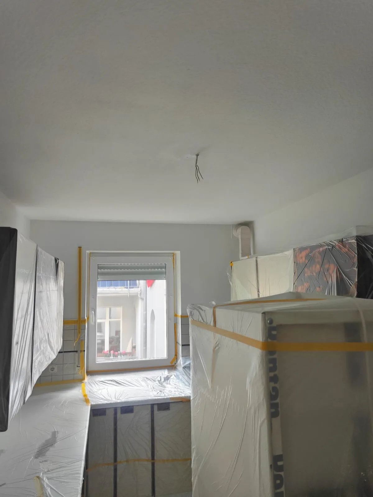 Küche während Malerarbeiten – Geräte abgedeckt, Decke gestrichen