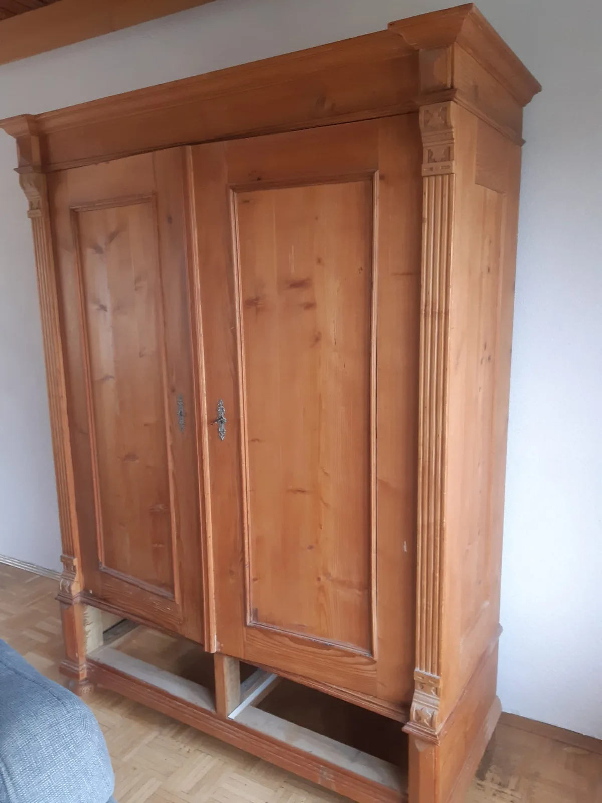 Wohnzimmer vor Renovierung – Ecksofa und antiker Schrank