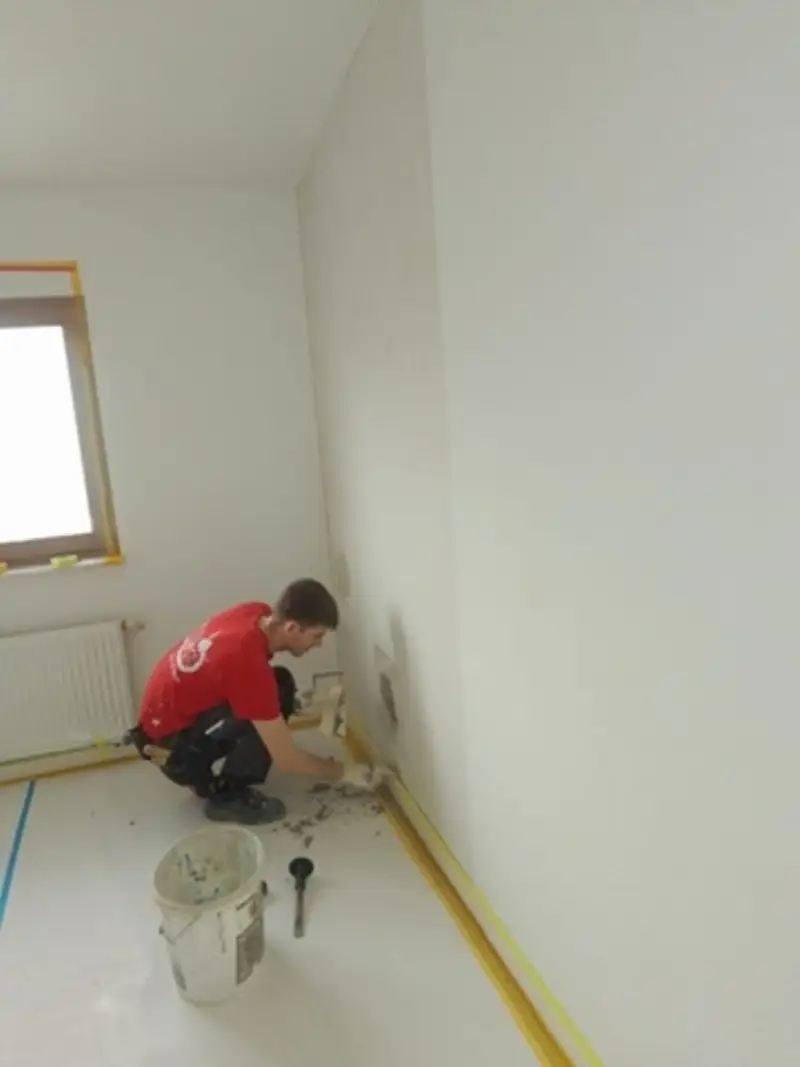 Andymen-Maler spachtelt Wand im Innenbereich