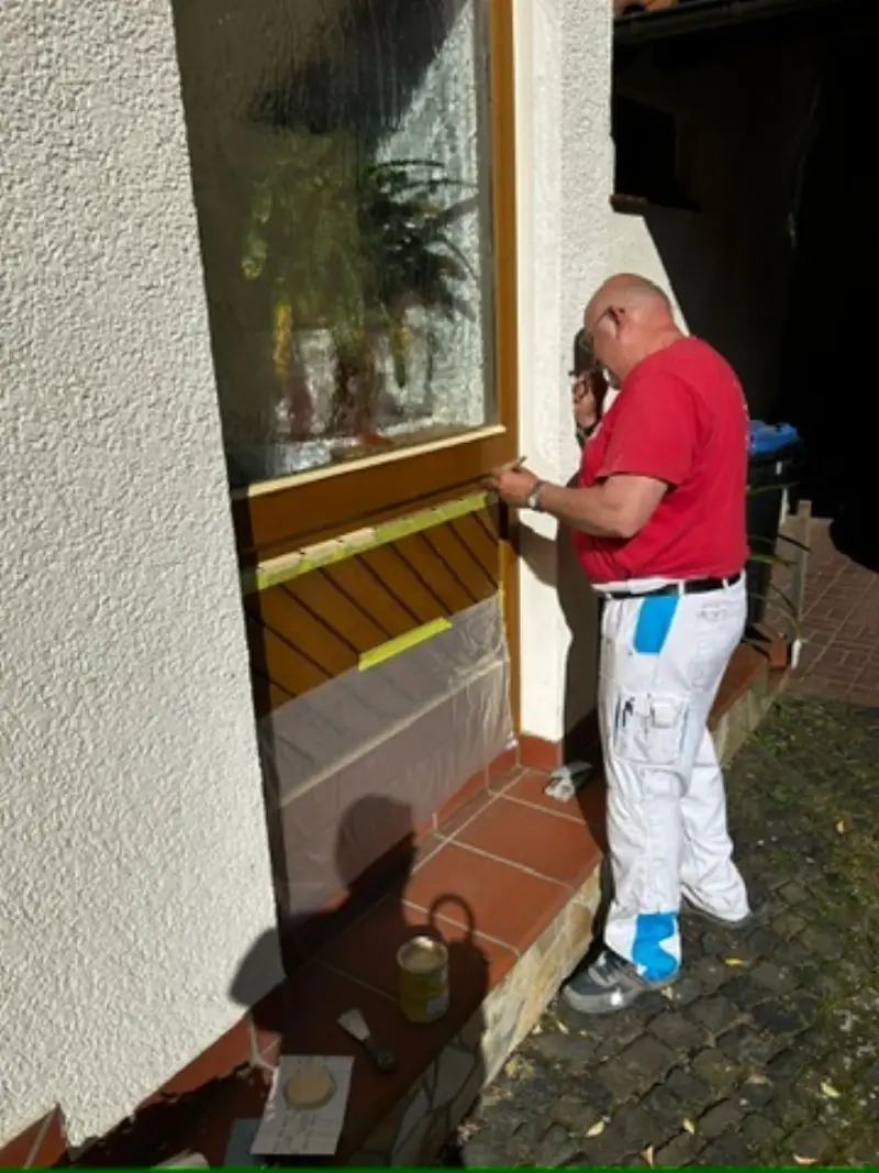 Andymen-Maler tapeziert Wand mit Vliestapete